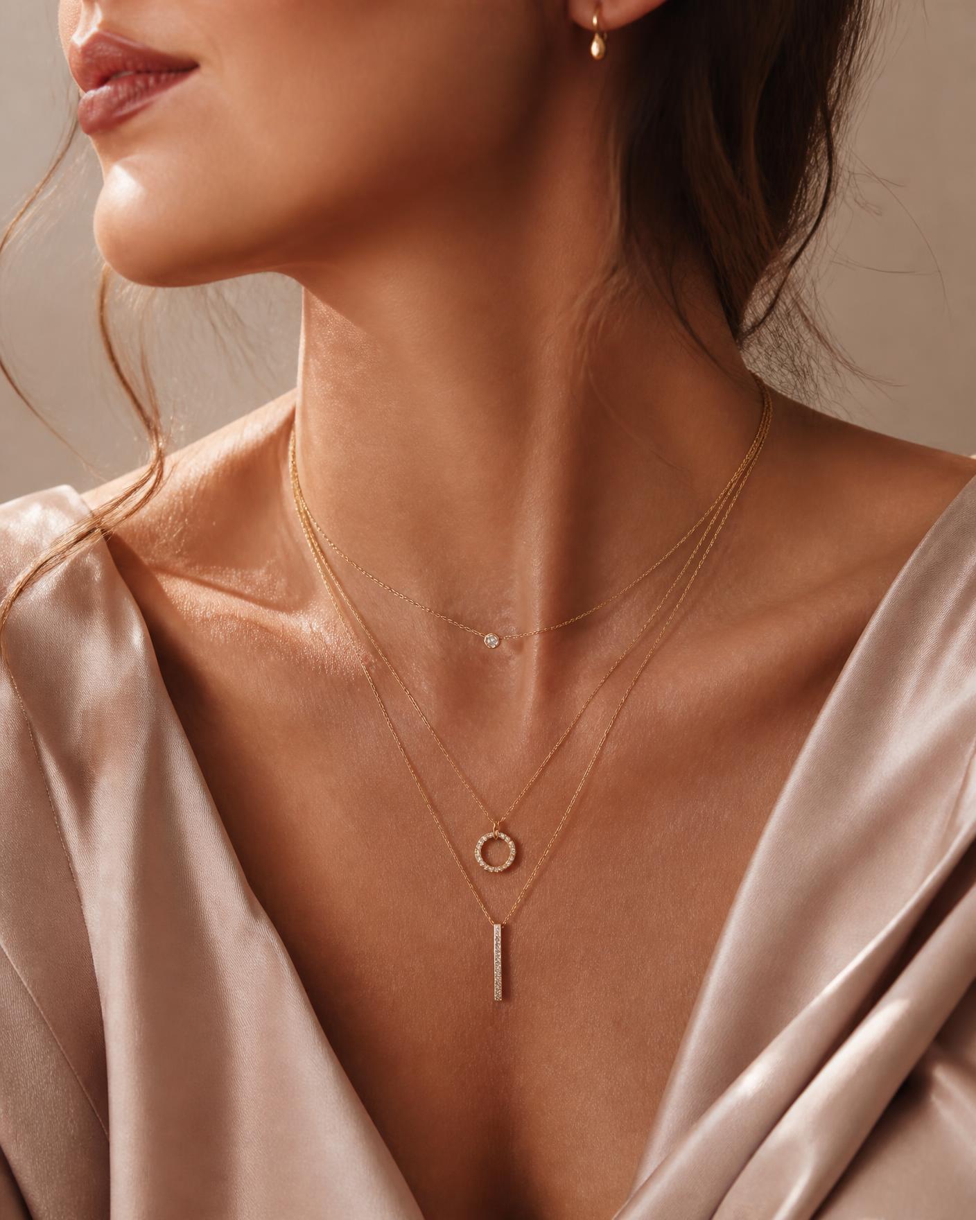 Woman wearing layered delicate gold necklaces